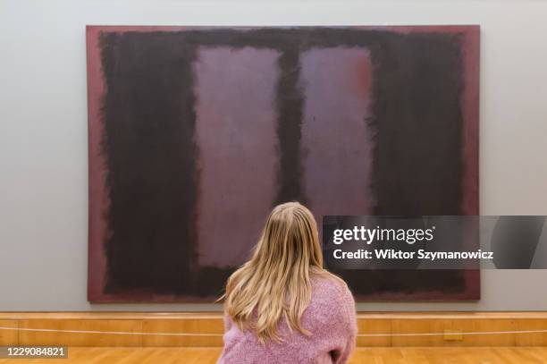 Gallery staff member looks at Mark Rothko's The Seagram Murals: Black on Maroon oil paint, acrylic paint, glue tempera and pigment on canvas during a...