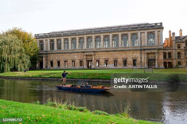 Boat punts past Wren library at Trinity College, part of the University of Cambridge, in Cambridge, eastern England, on October 14, 2020.