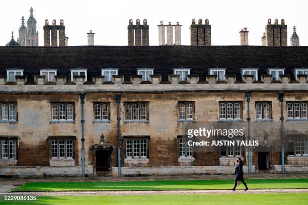 Person walks through Great Court at Trinity College, part of the University of Cambridge, in Cambridge, eastern England, on October 14, 2020.