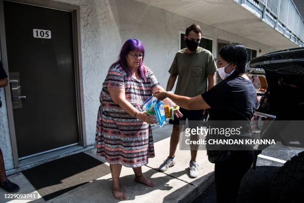 The head of the Kissimmee-Poinciana Homeless Outreach, Barbie Austria, donates essentials to jobless living in a motel in Kissimmee, Florida on...