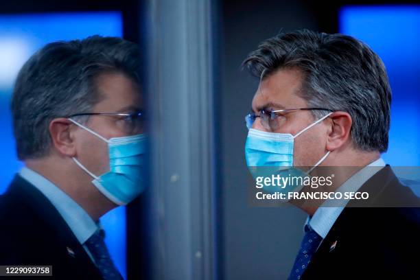Croatia's Prime Minister Andrej Plenkovic is reflected in a glass door as he leaves during departures at an EU summit in Brussels, on October 15,...