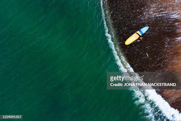 This aerial view image shows surfers from a local Surf Camp in the water during a surfing session on September 30, 2020 in Klitmoller, Denmark. - On...