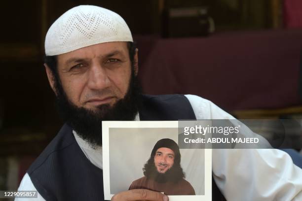 In this picture taken on September 25 Afghan refugee Roman Khan displays a photograph of his brother Asadullah Haroon, who is detained in Guantanamo...