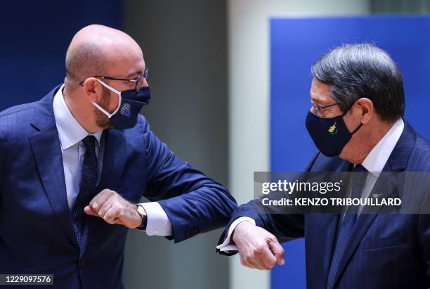 Cyprus' President of the Republic Nicos Anastasiades and President of the European Council Charles Michel , wearing face masks, greet each other with...