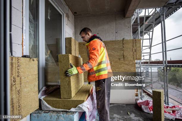 Worker handles wall insulation blocks at the under-construction Cordia Management Kft. Young City residential development in Budapest, Hungary, on...