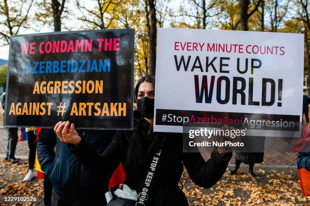 An Armenian woman is holding two placard, during the Armenian community protest against Israel's arms deliveries to Azerbaijan, in The Hague, on...