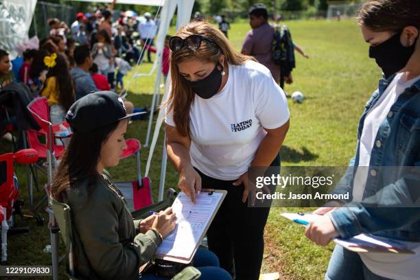 Sandra Amado Gomez and her daughter Aylen Agostina Gomez registers a woman to vote during halftime at the championship game of soccer on Sunday,...