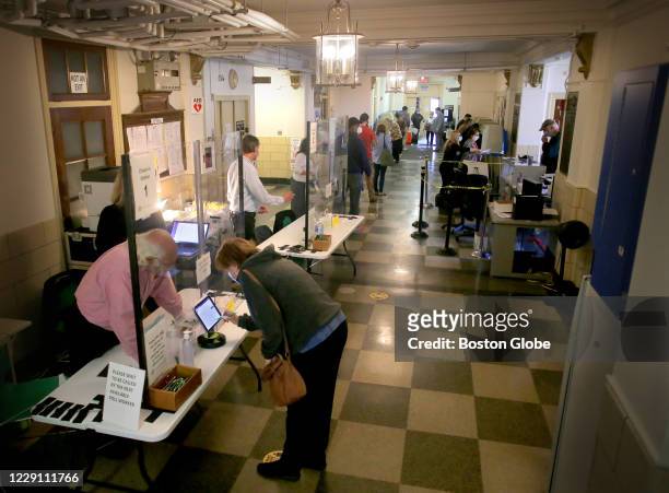 Voters signed in before casting their ballots at Cranston City Hall in Cranston, RI on Oct. 13, 2020. Voters cast ballots in the first day of early...