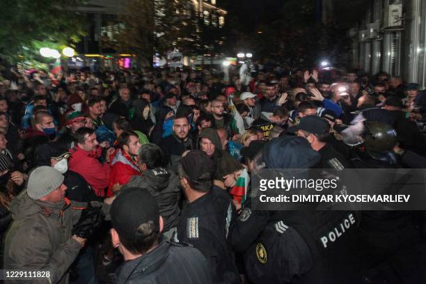 Demonstrators clash with riot police during an anti-government protest near the parliament building in Sofia on October 16, 2020. - On the 100th day...