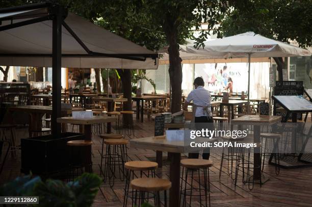 Waiter preparing a terrace outside 'Beluga Malaga' restaurant. The Covid-19 pandemic has damaged the tourism and other service sector industries in...