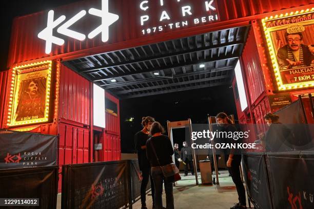People arrive to attend the play ""Kaldirim sercesi" about the life of French singer Edith Piaf at an open air theatre in Istanbul, on October 6,...