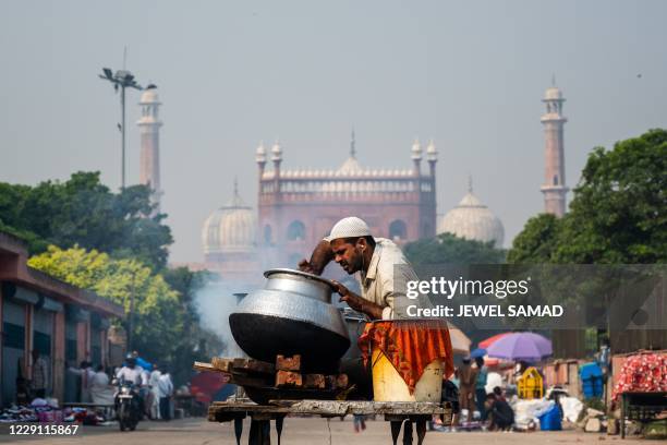 Vendor arranges Biryani a traditional mixed rice dish, sitting on his push-van while waiting for customers in the old quarters of New Delhi on...