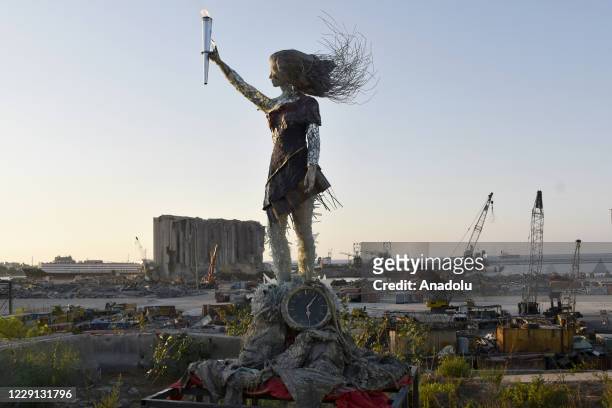 Torch lit on the hand of a symbolic sculpture is seen after protesters gather at Martyrs' Square to march towards Beirut Port where a massive...