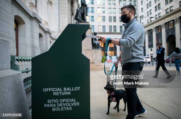 Voter casts his early voting ballot at drop box outside of City Hall on October 17, 2020 in Philadelphia, Pennsylvania. With the election only a...