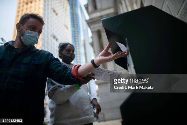 Voters cast their early voting ballot at drop box outside of City Hall on October 17, 2020 in Philadelphia, Pennsylvania. With the election only a...