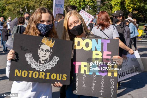 Protesters hold placards expressing their opinions at Washington Square Park during the demonstration. Thousands took to the streets across the US...