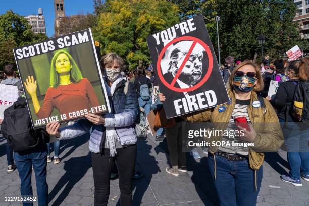 Protesters hold placards expressing their opinions at Washington Square Park during the demonstration. Thousands took to the streets across the US...