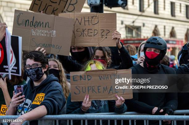 Counter-protests hold up signs at a gathering of the far right group 'Super Fun Happy America' in Copley Square in Boston, Massachusetts on October...