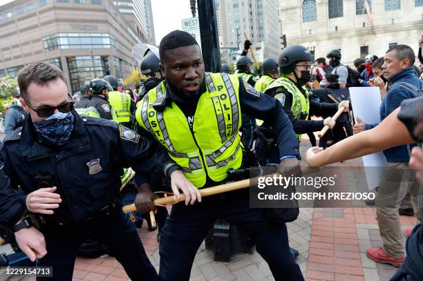 Counter protesters and police clash outside of a gathering of the far right group 'Super Fun Happy America' as they hold a protest in Copley Square...