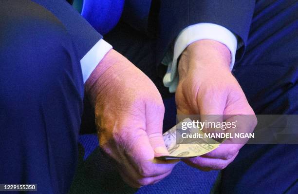 President Donald Trump counts banknotes for an offering during service at the International Church of Las Vegas in Las Vegas on October 18, 2020. -...