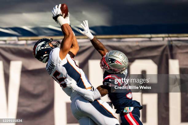 Albert Okwuegbunam of the Denver Broncos attempts to catch a pass as he is defended by Jonathan Jones of the New England Patriots during the second...