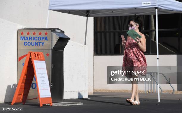 People deposit their mail-in ballots for the US presidential election at a ballot collection box in Phoenix, Arizona on October 18, 2020. - Arizona...