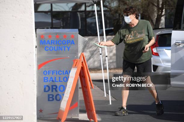 People deposit their mail-in ballots for the US presidential election at a ballot collection box in Phoenix, Arizona on October 18, 2020. - Arizona...