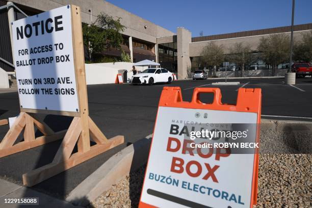 People deposit their mail-in ballots for the US presidential election at a ballot collection box in Phoenix, Arizona on October 18, 2020. - Arizona...