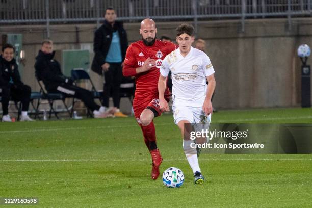 Atlanta United FC Midfielder Emerson Hyndman dribbles the ball up the field with Toronto FC Defender Laurent Ciman in pursuit during the first half...