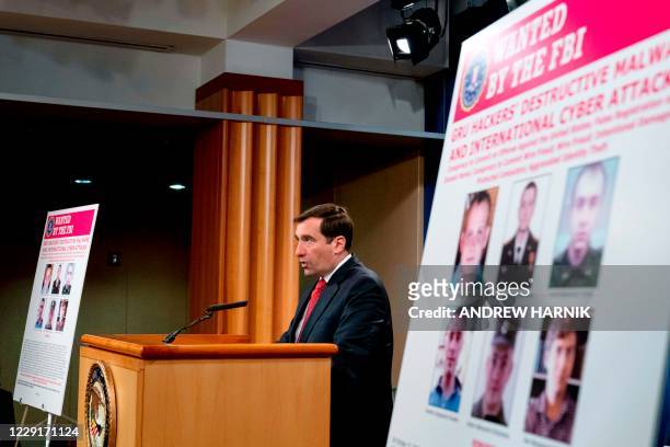 Posters showing six wanted Russian military intelligence officers is displayed as Assistant Attorney General for the National Security Division John...