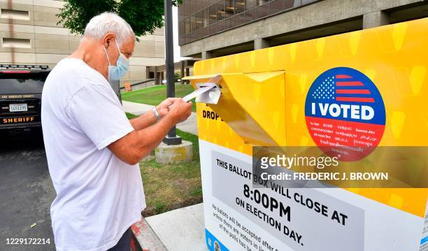 Voter drops his ballot for the 2020 US elections into an official ballot drop box at the Los Angeles County Registrar in Norwalk, California on...