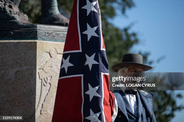 Braxton Spivey holds a confederate battle flag dressed in a Confederate army unifrom during a pro-Confederate flag protest by a group called "Flags...