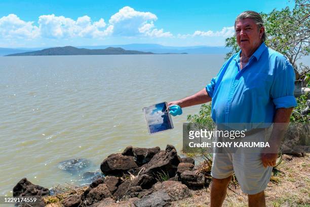 Murray Roberts who has lived on the shores of Lake Bogoria much of his life, like his father before him, is pictured in his compound holding an old...