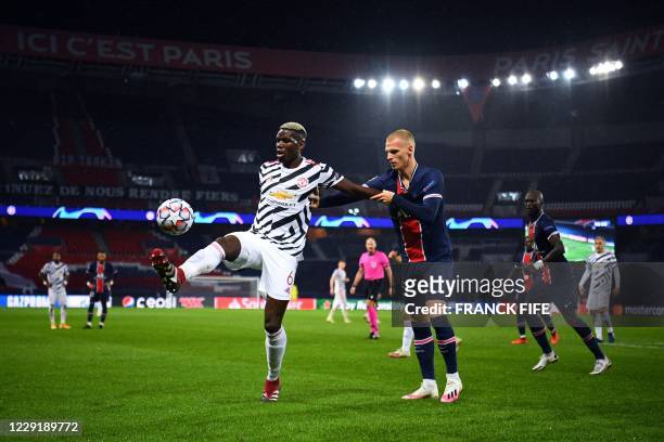 Manchester United's French midfielder Paul Pogba vies for the ball with Paris Saint-Germain's Dutch defender Mitchel Bakker during the UEFA Champions...