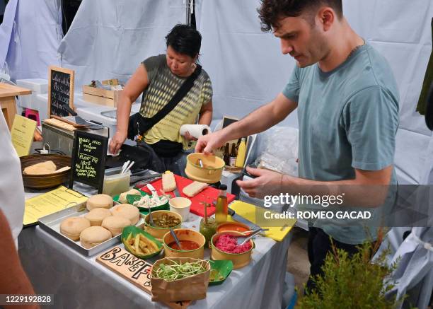 In this photo taken on October 18, 2020 Taksina Nuangsri and chef Edoardo Bonavolta prepare dishes at the Barefood Bangkok stall specialising in...