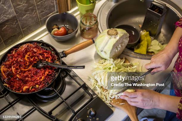 October 15: Oksana Chadaieva chops a cabbage in her kitchen in order to cook borscht in Kyiv, Ukraine on October 15, 2020. Chadaieva loves to cook...