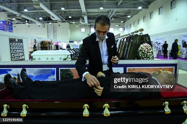 Participant applies makeup on the copy of Soviet state founder Vladimir Lenin's body during a funeral exhibition in Moscow on October 21, 2020. - The...