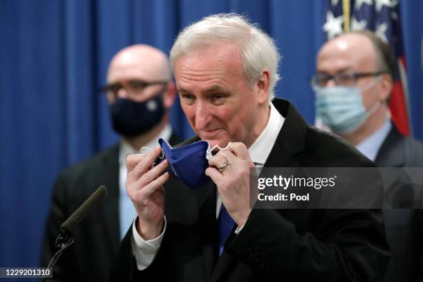 Deputy U.S. Attorney General Jeffrey Rosen removes his face mask as he speaks at a news conference to announce the results of the global resolution...