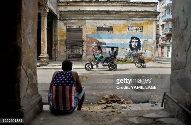Man wearing a tank top with a design of the US flag rests in Havana on October 21 amid the COVID-19 novel coronavirus pandemic. - The novel...