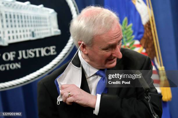 Deputy U.S. Attorney General Jeffrey Rosen removes his face mask as he announces that Purdue Pharma LP has agreed to plead guilty to criminal charges...