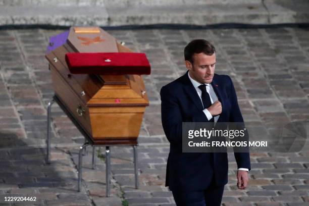 French President Emmanuel Macron pays his respects by the coffin of Samuel Paty's coffin inside Sorbonne University's courtyard in Paris on October...