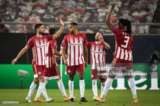 Olympiakos' Greek midfielder Georgios Masouras celebrates with teammates after scoring a goal during the UEFA Champions League Group C first-leg...