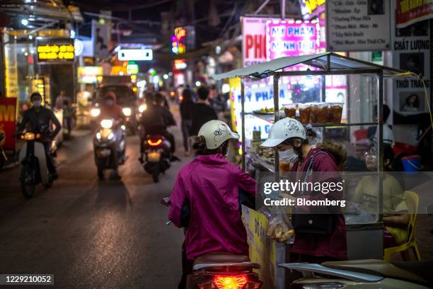 Customers buy street food from a food cart near the Van Trung Industrial Park in Viet Yen district, Bac Giang province, Vietnam, on Friday, Oct. 9,...