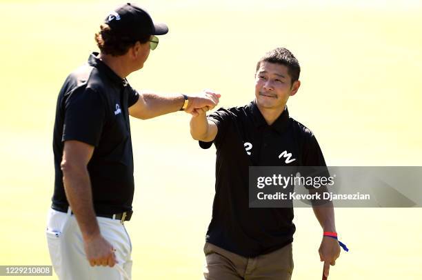 Yusaku Maezawa, founder and former CEO of Zozo, bumps fists with Phil Mickelson on the eigtheenth tree after completing the pro am ahead of the Zozo...