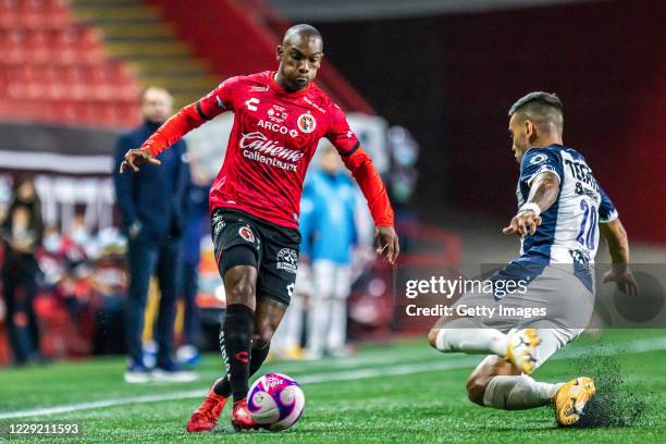 Fabian Castillo of Tijuana drives the ball as Sebastián Vegas of Monterrey slides to defend during the Final first leg match between Tijuana and...