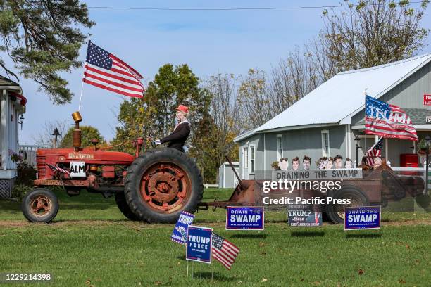 Pro-Trump display features a Donald Trump mannequin on a tractor pulling a wagon containing the heads of Trump's political rivals.