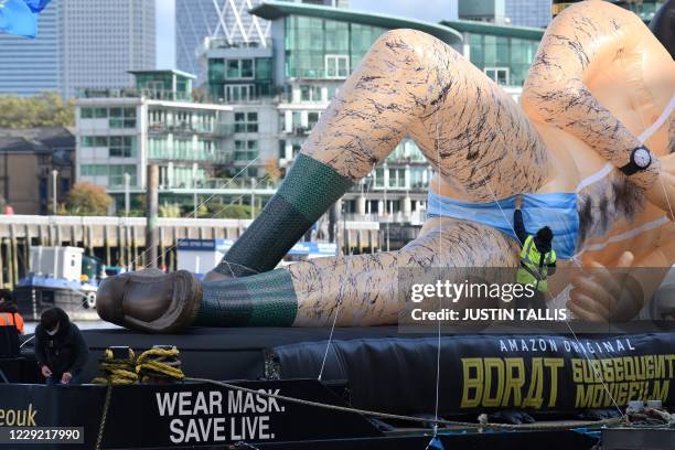 Worker adjusts the mankini on an inflatable in the form of Borat, UK comedian Sacha Baron Cohens fictional Kazakh reporter as it floats down the...
