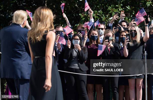 President Donald Trump and First Lady Melania Trump walk to greet well-wishers prior to departing on Marine One from the South Lawn of the White...