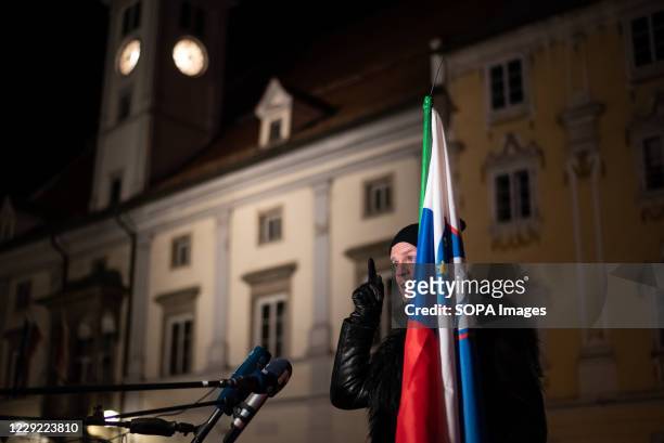 Protester against the night curfew enforcement and lockdown restrictions speaks to press while holding the Slovenian flag past the night curfew...