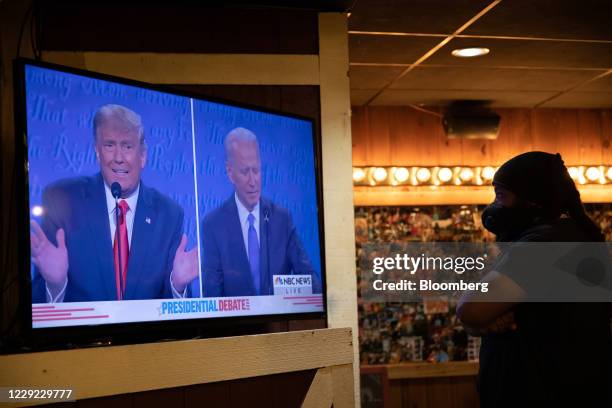 Bartender wearing a protective mask watches the U.S. Presidential debate between President Donald Trump and Democratic candidate Joe Biden at a bar...